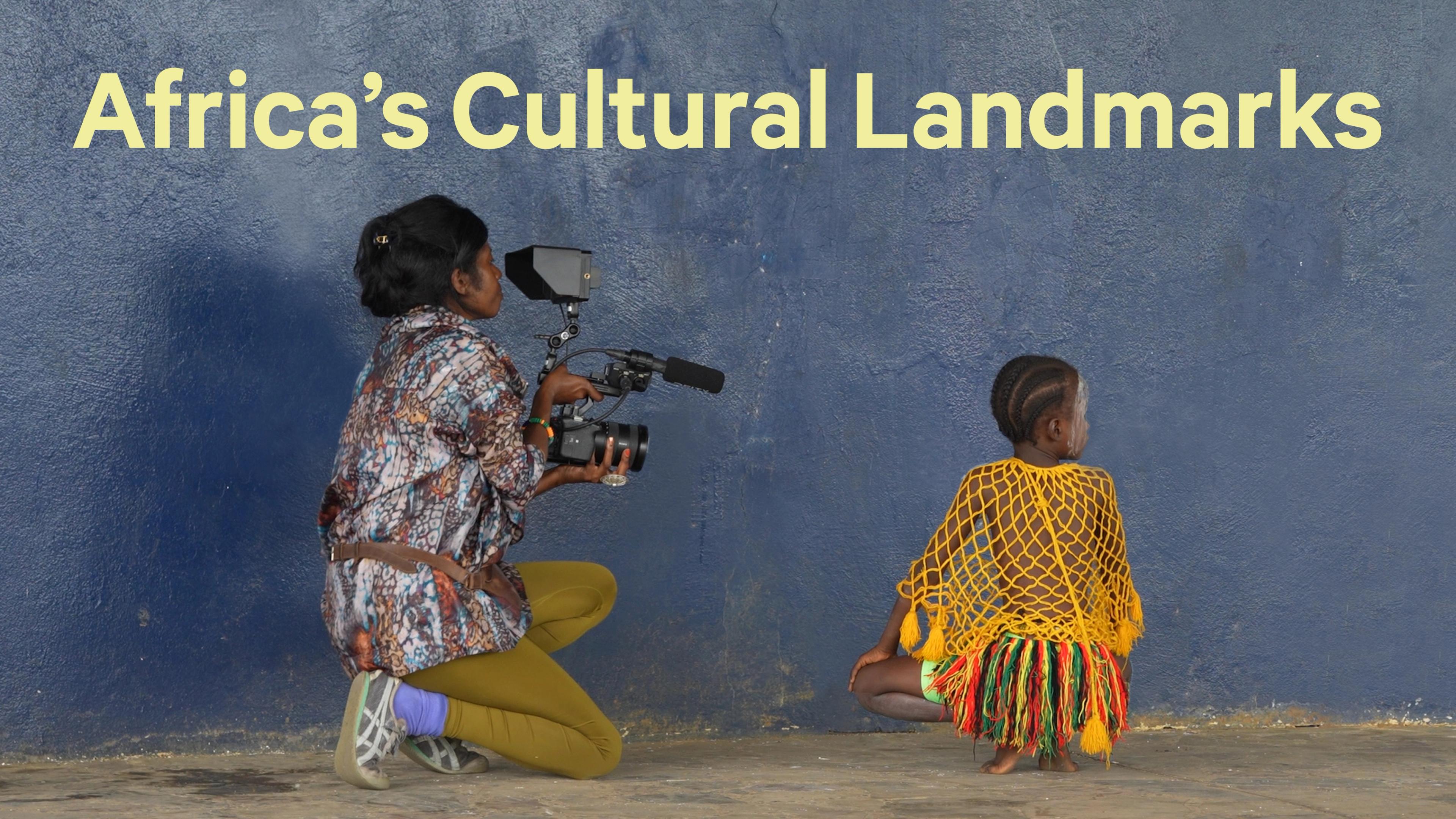 Woman holding a camera and filming a child in dancing attire, with text at the top reading "Africa's Cultural Landmarks"