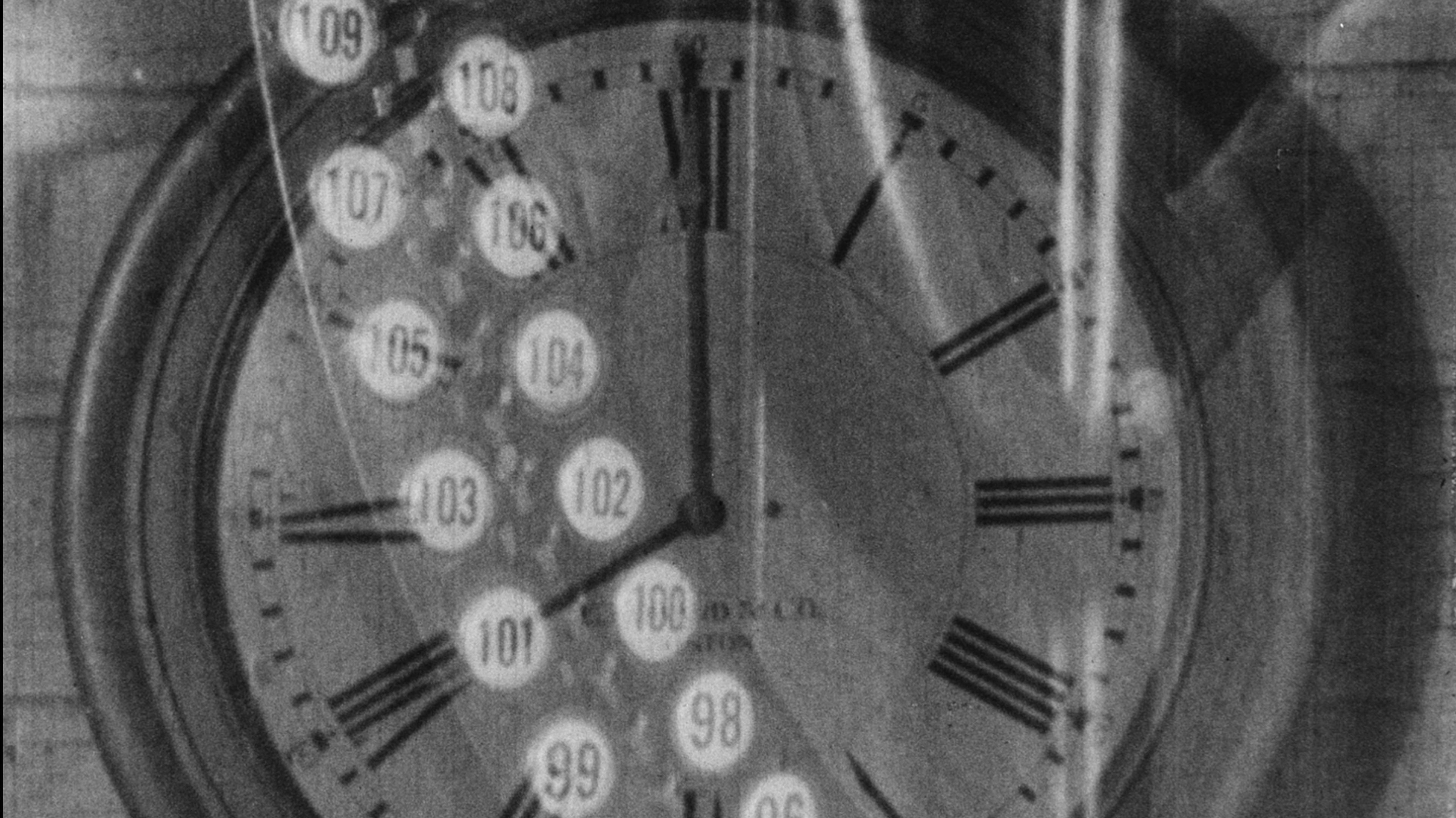 A black-and-white still from the 1928 film Behind the Scenes: The Working Side of the Museum, which depicts the superimposed image of an old-fashioned time-card machine over the face of a wall clock