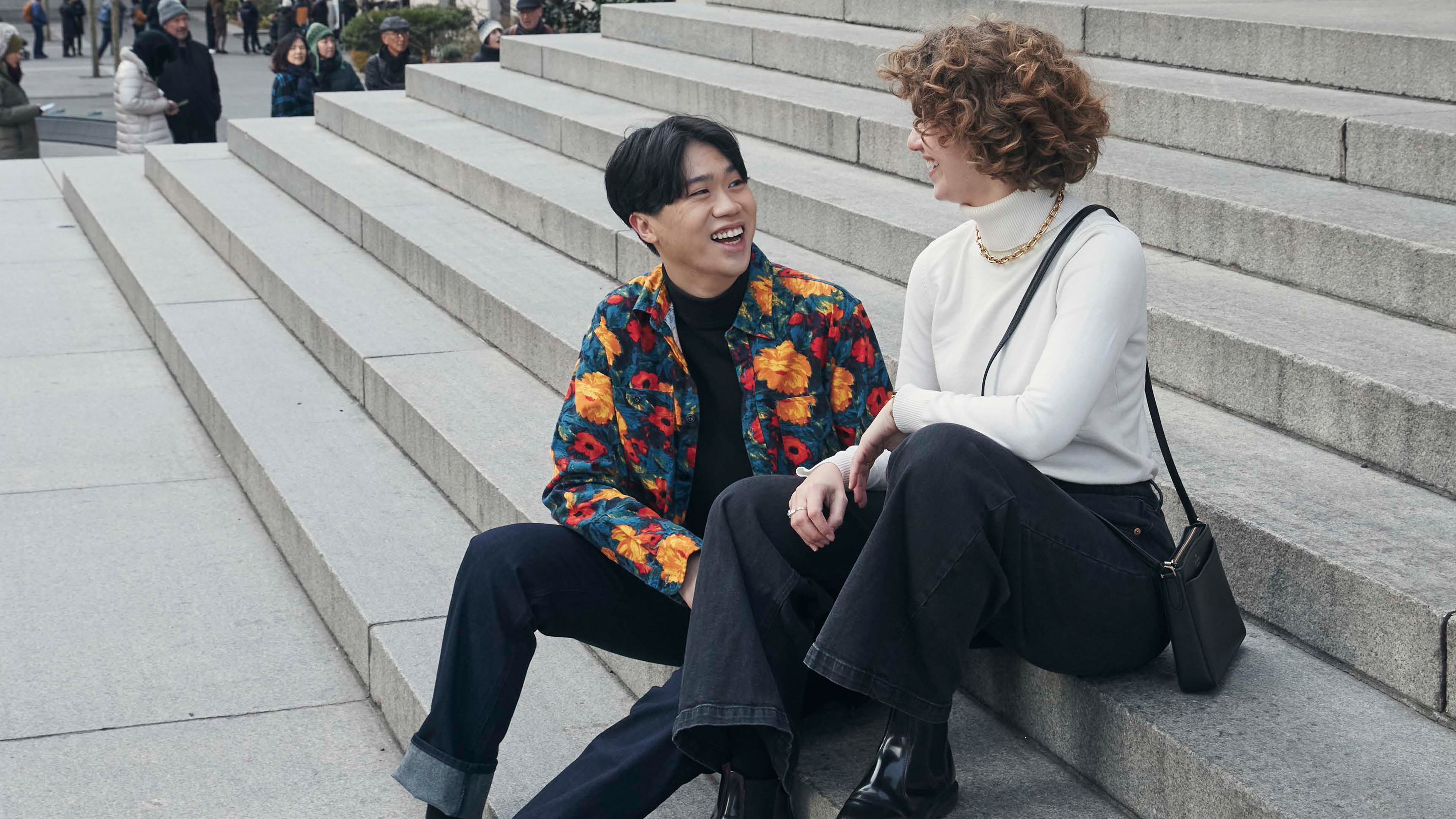 Two people sitting on The Met steps. 